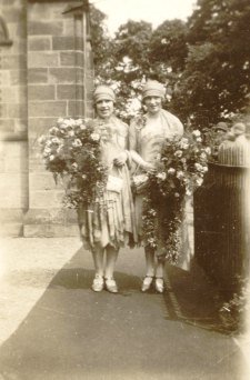 1920s Bridesmaids wearing cloche hats with huge bouquets of flowers