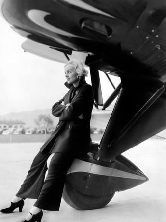Carole Lombard sitting on an aircraft wheel